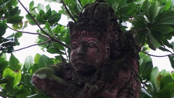 BALI, INDONESIA - 22 APRILE 2018: Scultura in pietra massiccia rossa intagliata a mano di creatura spirituale e sacrale — Video Stock