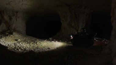 Mağaranın içinde birkaç kuadrosiklet ışıkları açık bir şekilde hareket ediyor..