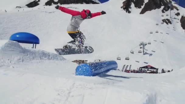 SOCHI, RUSIA - 2 DE ABRIL DE 2016: Snowboarder slide on blue kicker. Día soleado. Estación de esquí. Gente. Deporte extremo — Vídeo de stock