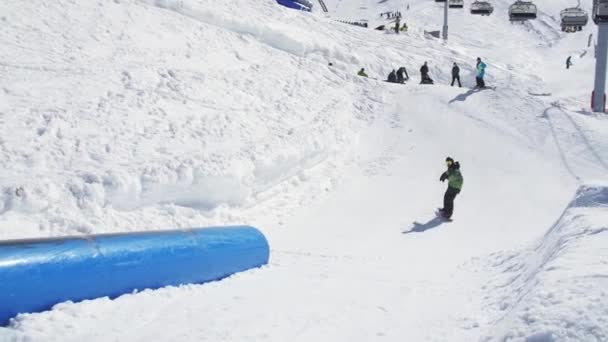 Soči, Rusko - 2. dubna 2016: Snowboardista na kopané. Slunečný den. Lyžařské středisko. Lidi. Extrémní sport. — Stock video