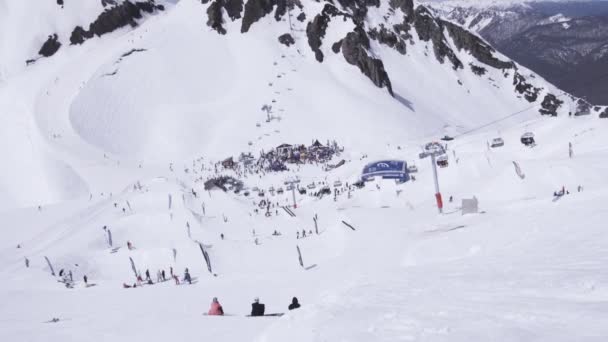 Sochi, Ryssland - 2 april 2016: Skidanläggning. Snowboardåkare och skidåkare. Lägret. Människor. Landskap av berg. — Stockvideo