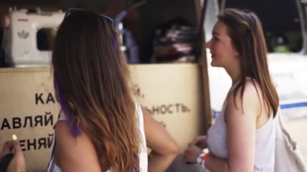 Duas jovens no quiosque de alfaiataria fora no evento de verão — Vídeo de Stock