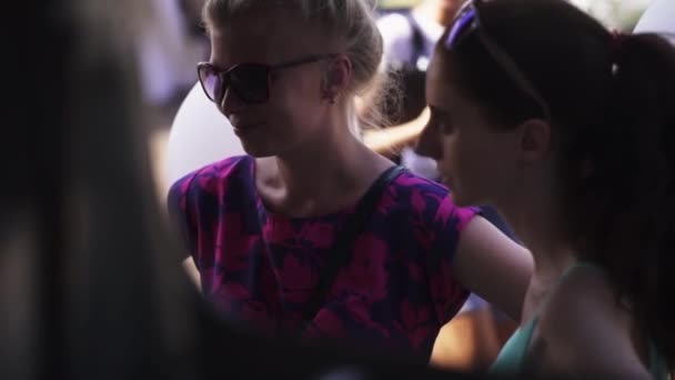 Unga söta flickor i solglasögon står i skuggan på sommaren fe — Stockvideo