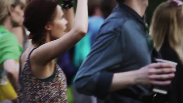 Meisje in fedora hoed dansen actief in menigte in de buurt scène op open een — Stockvideo