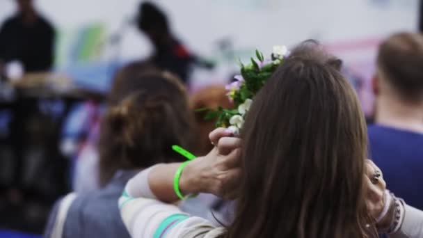 Flicka i blomma krans dans i folkmassan nära scenen på friluftsliv fe — Stockvideo