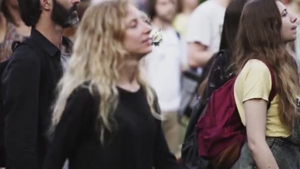 Jong blond meisje in zwart shirt dansen in mensen menigte op open — Stockvideo