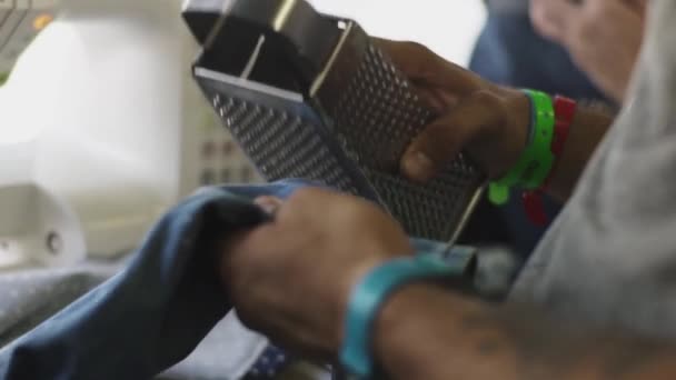 Mužské paže dělat dekorativní slzy s struhadlem na džín — Stock video