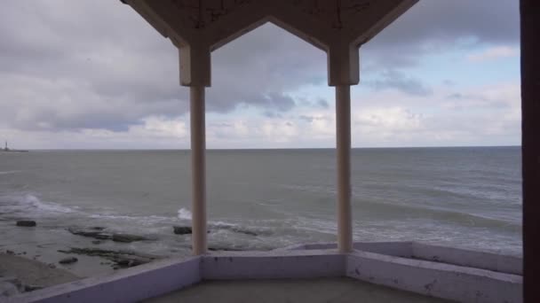 Sahillere dalgaların düştüğü boş kıyı şeridindeki tatil merkezinden manzara — Stok video