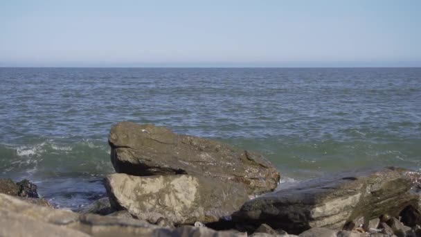 Increíble vista natural de la costa rocosa vacía con olas que caen en el día soleado . — Vídeo de stock