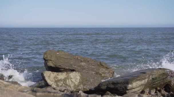 Fascinující přírodní scenérie skalnatého pobřeží s padajícími vlnami za slunečného dne. — Stock video