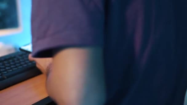 L'homme assis à table utilise son smartphone et fume, tapant sur le clavier .