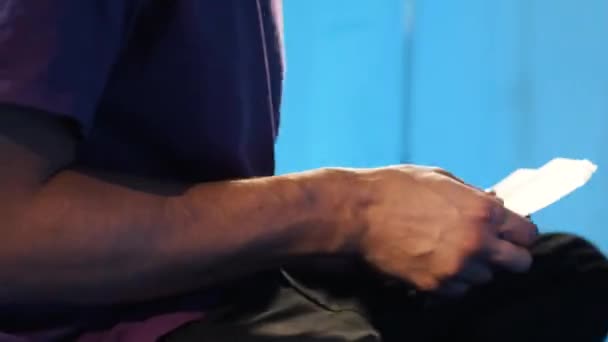 Rotating camera shows man in t-shirt carefully counting USA dollars bills. — Stock Video