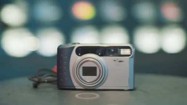 Draaiende camera toont oude grijze semi-automatische film fotocamera op tafel. — Stockvideo