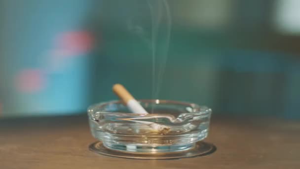 Rotation process of stylish glass ashtray with burning cigarette placed inside. — Stock Video