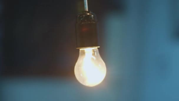 Rotação dinâmica em torno de um acendeu a luz da lâmpada pendurada no teto . — Vídeo de Stock