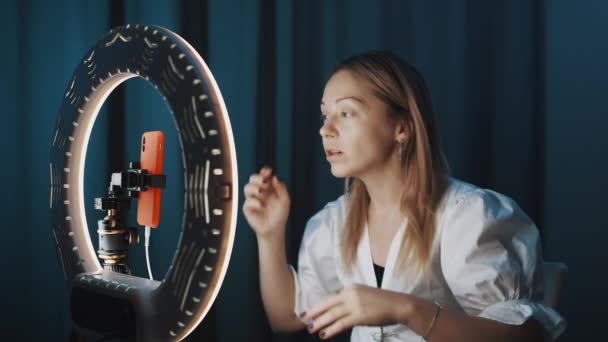 Blondynka młoda kobieta blogger moda mówi o makijaż przed ring light — Wideo stockowe