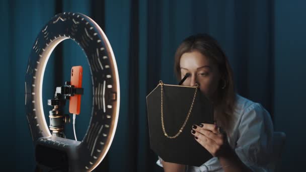Žena módní blogger aplikuje make-up pomocí štětce, držení zrcadla v ruce. — Stock video