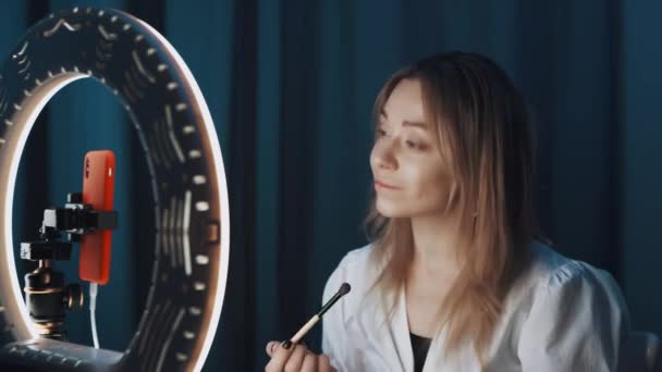 Loira madura mulher beleza blogger acaricia seu cabelo na frente do anel de luz . — Vídeo de Stock