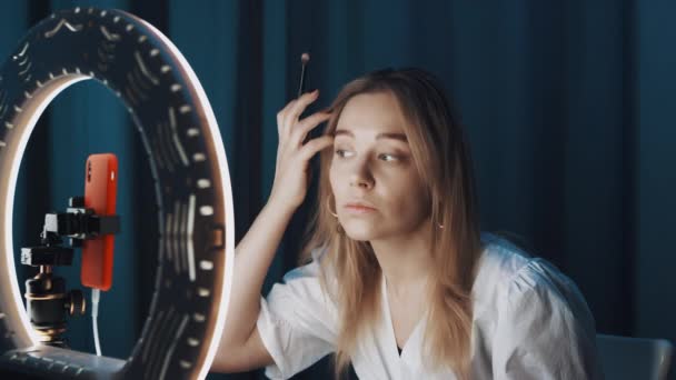 Disparos de una joven bloguera de moda haciendo sus ojos frente a la lámpara del anillo . — Vídeo de stock