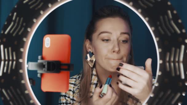 Vista del blogger femenino de belleza aplicando lápiz labial frente a la luz del anillo para el canal — Vídeo de stock