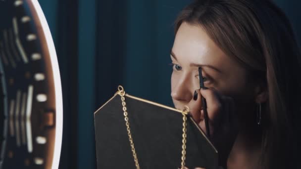 Blogger de belleza rubia bastante femenina llena sus cejas delante de la luz del anillo — Vídeos de Stock