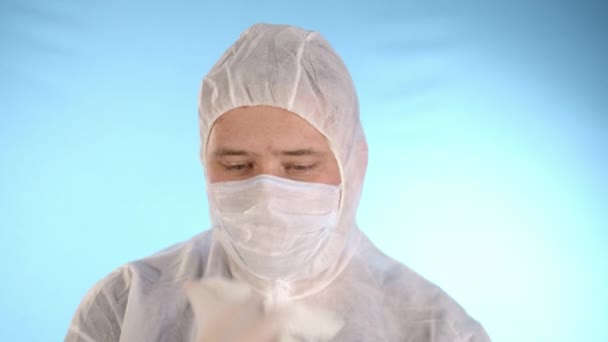 Hombre Caucásico Con Traje Protección Blanco Máscara Médica Fondo Azul — Vídeo de stock