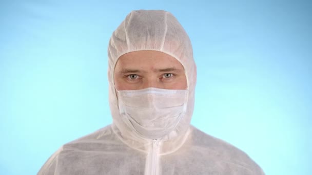 Beyaz Koruyucu Takım Elbiseli Tıbbi Maskeli Mavi Arka Planda Lastik — Stok video