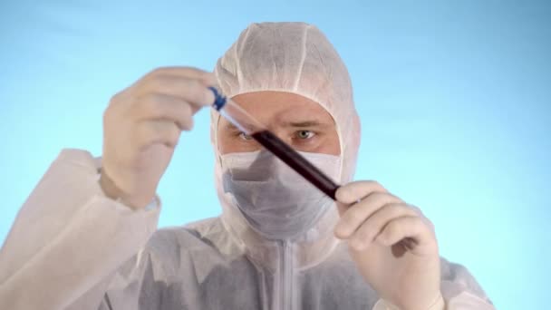 Kaukasischer Mann Weißem Schutzanzug Medizinischer Maske Gummihandschuhen Auf Blauem Hintergrund — Stockvideo