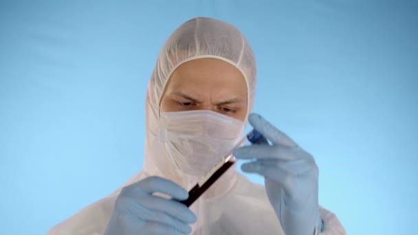 Kaukasier Weißem Schutzanzug Medizinischer Maske Gummihandschuhen Auf Blauem Hintergrund Hält — Stockvideo