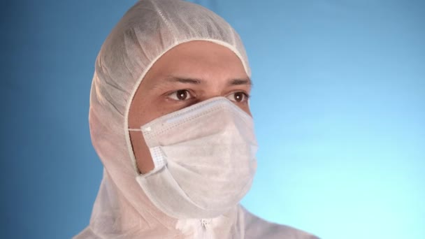 身穿白色工作服 戴防护面具 戴蓝色橡胶手套 在蓝色背景感染病毒 咳嗽和吐血的白人男性实验室技术员 — 图库视频影像