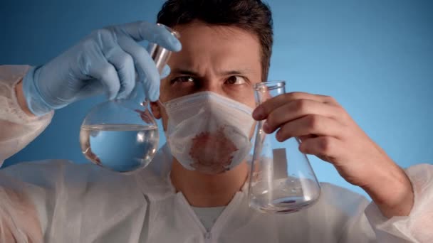 Homem Caucasiano Traje Protetor Máscara Médica Fundo Azul Mistura Transfusíveis — Vídeo de Stock