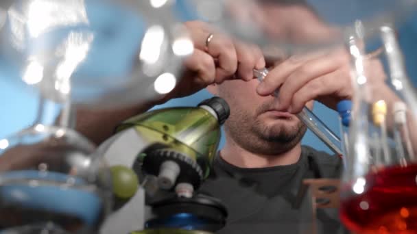 코카서스 사람은 액체를 현미경 스탠드에 흔들고 약품에 피이드 유리로 위에는 — 비디오