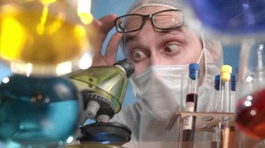 Kafkasyalı sakallı adam mikroskop tezgahına çıktı ve bu keşiften çok memnun. Cam şeffaf masa üzerinde çok renkli çözeltilere sahip kaplar, mataralar var.