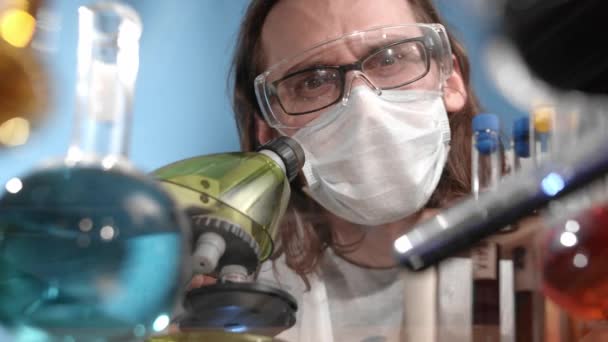 의료용 마스크를 착용하고 작업복을 착용하고 과학자들은 시험관을 내리고 액체를 냅킨으로 — 비디오