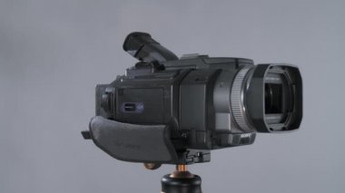 Stüdyoda fındıklı arka planda tripoda 360 dönerek ekranı çeviren kompakt video kamera sony Handycam minidv.