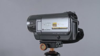 Stüdyodaki fındık grisi arka planda 360 derece dönen kompakt video kamera Sony Handycam Minidv.