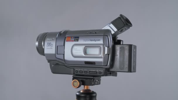 Npf电池旋转360的小型摄像机Sony Handycam Minidv在工作室的三脚架核灰色背景下 — 图库视频影像