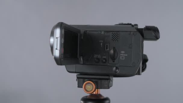 演播室里 紧凑型摄像机 带有翻转屏幕旋转360的Sony手持摄像头 三脚架在原子核灰色背景下 — 图库视频影像