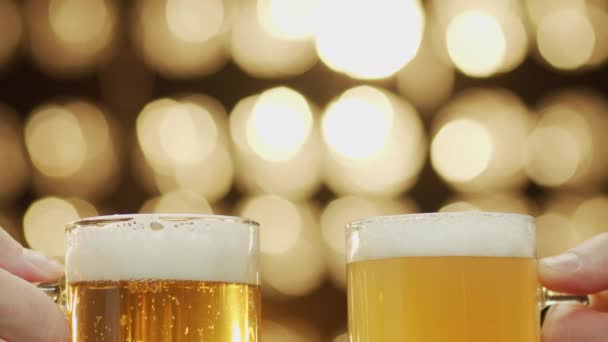 Two friends clang beer spilling beer bokeh background close-up. — Stock Video