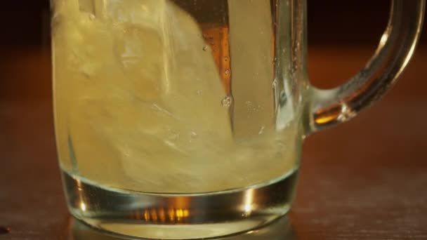 Beer pouring into a mug, at bar counter panning upwards macro shot. — Stock Video