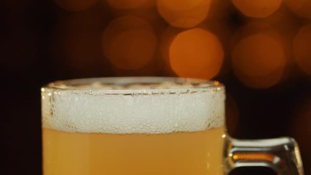 Μακρό πλάνο της κούπας γεμάτη μπύρα στέκεται στην κορυφή του πάγκου, panning κάτω . — Αρχείο Βίντεο