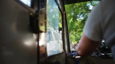 BEIJING, ÇİN - 16 HAZİRAN 2017: Çinli bir kadın tuk tuk şoförü Pekin 'deki bir yol üzerinde diğer tribünler ve yayalar arasında at sürüyor.