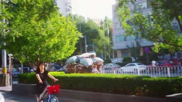 中国北京 2017年6月16日 中国男子在北京夏季中心驾驶拖轮的司机将废纸和垃圾装在他的三轮摩托车行李箱中 附近骑自行车的女人 — 图库视频影像