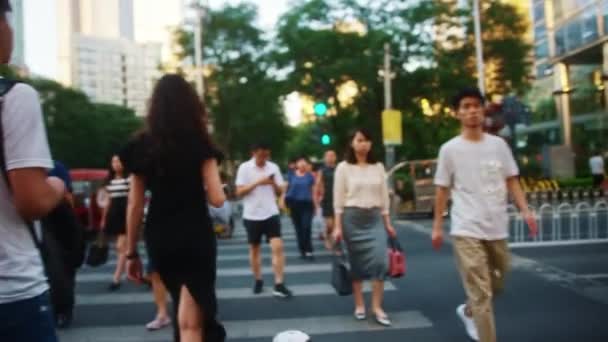 BEIJING, CHINA - JUNI 16, 2017: Het publiek van Chinese vrouwen en mannen kruist de oversteekplaats bij groen licht van verkeerslichten — Stockvideo