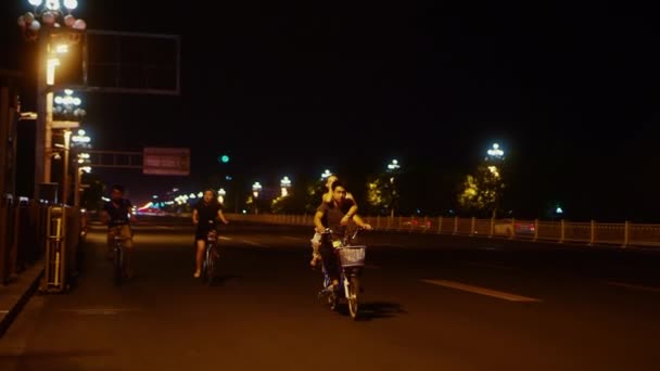BEIJING, CHINA - JUNHO 16, 2017: Pequim à noite. Em uma estrada vazia, os moradores da China andam de bicicleta — Vídeo de Stock