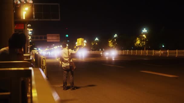 BEIJING, CHINA - JUNHO 16, 2017: Noite de verão Pequim. Chinês mulher está de pé na paragem de autocarro . — Vídeo de Stock