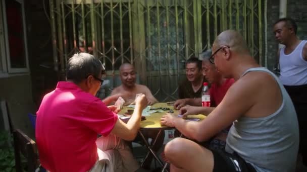 BEIJING, ΚΙΝΑ - 16 ΙΟΥΝΙΟΥ 2017: Κινέζοι στην αυλή του Πεκίνου παίζουν ντόμινο σε ένα τραπέζι στο δρόμο. — Αρχείο Βίντεο
