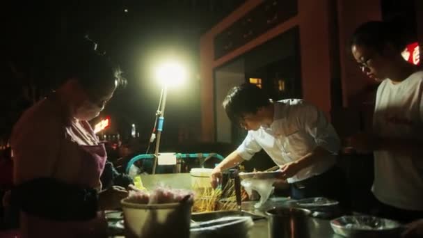 BEIJING, CHINA - 16 DE JUNIO DE 2017: La cocinera china prepara comida asiática por la noche en la calle. Verano Beijing — Vídeo de stock