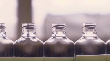 Dezenfektanlar için boş plastik şişeler, kişisel koruyucu ekipman üretimi için fabrikadaki taşıyıcı bant boyunca ilerliyor..
