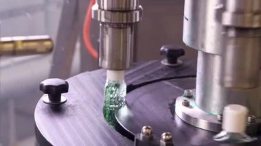Dezenfektan jeli için plastik şişeler, kişisel koruyucu ekipman üretimi için fabrikadaki taşıyıcı bant boyunca ilerliyor..